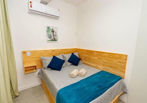 a bedroom with a bed with blue pillows at Carnaval! Apt. moderno no Porto da Barra in Salvador