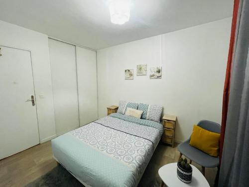 a small bedroom with a bed and a chair at La Chambre in Saint-Denis