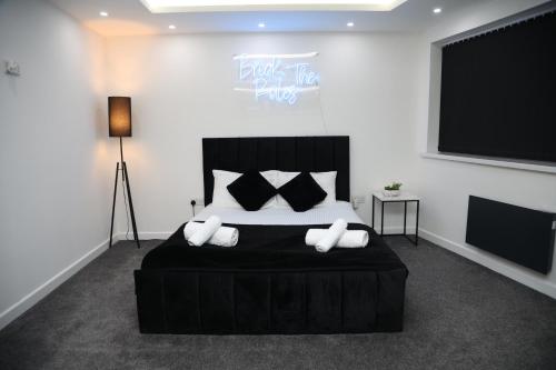 una camera da letto con un grande letto nero con cuscini di The Hideaway a Birmingham