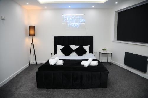 a bedroom with a large black bed with pillows at The Hideaway in Birmingham