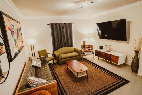 a living room with a couch and a flat screen tv at Casa Panda near Airport / Shopping Plaza and International Border in Tijuana