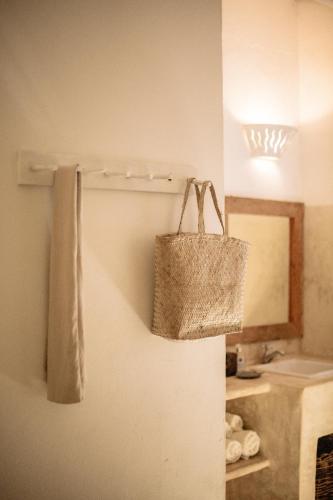 a bathroom with a basket hanging on the wall at Pousada Lagoa in Caraíva