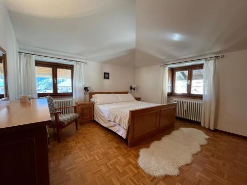 - une chambre avec un lit, un bureau et 2 fenêtres dans l'établissement A Bormio con gioia, à Bormio