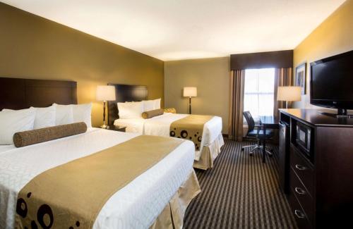a hotel room with two beds and a flat screen tv at Best Western Plus Mishawaka Inn in South Bend