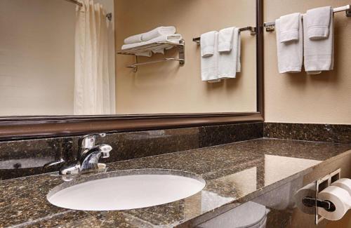 a bathroom with a sink and a mirror and towels at Best Western Plus Mishawaka Inn in South Bend