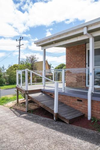 a porch on a brick building with a white rail at Views on the Avenue in Clifton Springs