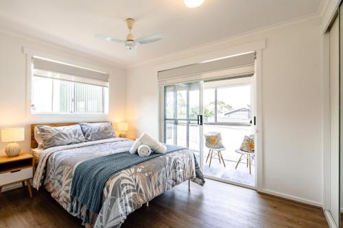 a bedroom with a bed and a sliding glass door at Views on the Avenue in Clifton Springs