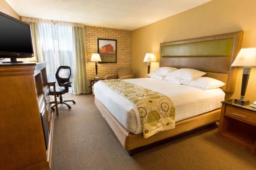 a hotel room with a bed and a flat screen tv at Drury Inn & Suites Paducah in Paducah