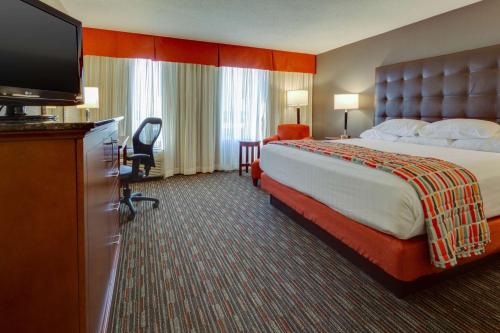 ein Hotelzimmer mit einem Bett und einem Flachbild-TV in der Unterkunft Drury Inn & Suites Memphis Southaven in Horn Lake