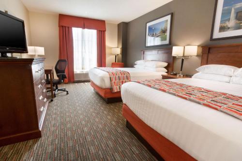 a hotel room with two beds and a flat screen tv at Drury Inn & Suites Dayton North in Dayton