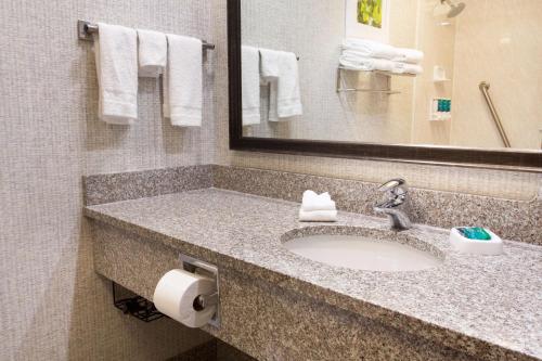 a bathroom with a sink and a mirror and towels at Drury Inn & Suites Dayton North in Dayton