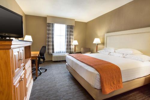 Habitación de hotel con cama y TV de pantalla plana. en Drury Inn & Suites San Antonio North Stone Oak, en San Antonio