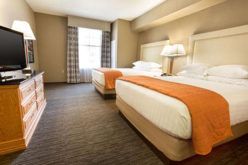 a hotel room with two beds and a flat screen tv at Drury Inn & Suites San Antonio North Stone Oak in San Antonio