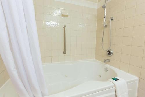 y baño con bañera y ducha con cortina de ducha. en Drury Inn & Suites San Antonio North Stone Oak, en San Antonio