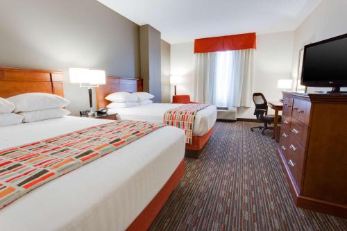um quarto de hotel com duas camas e uma televisão de ecrã plano em Drury Inn & Suites Greenville em Greenville