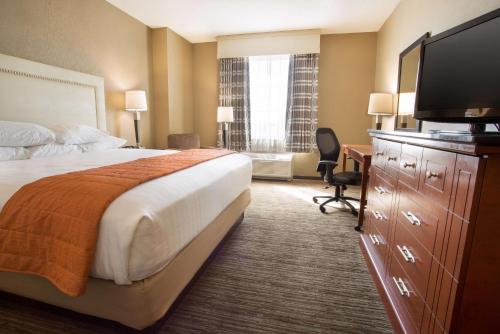 a hotel room with a bed and a flat screen tv at Drury Inn & Suites Cincinnati Sharonville in Sharonville