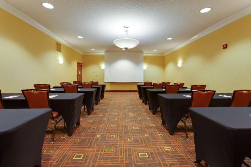 a conference room with tables and chairs and a whiteboard at Drury Inn & Suites St. Louis Forest Park in Saint Louis