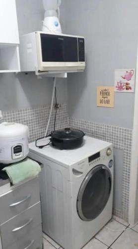 a kitchen with a washing machine and a microwave at Apartamento inteiro, completo para até 8 pessoas por locação Não é divido com outros pessoas apenas significa que vc pode locar que tem capacidade para até 8 pessoas mas a locação sempre é individual de quem locou in Campinas