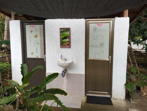 d'une petite salle de bains avec un lavabo et une porte. dans l'établissement Lagkaw Dos in Lagkaw Homestay, à Looc