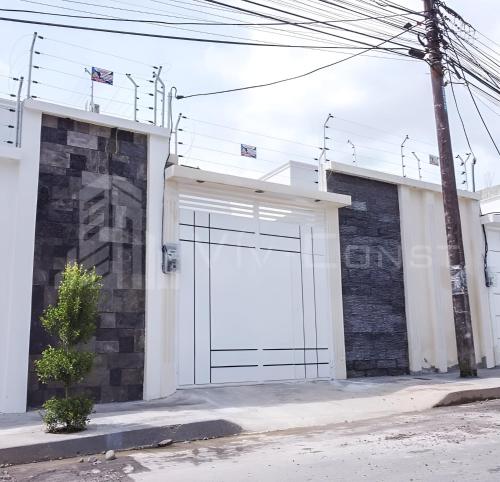 une porte de garage blanche sur le côté du bâtiment dans l'établissement Casa cerca del Terminal de SANTO DOMINGO, à Santo Domingo de los Colorados