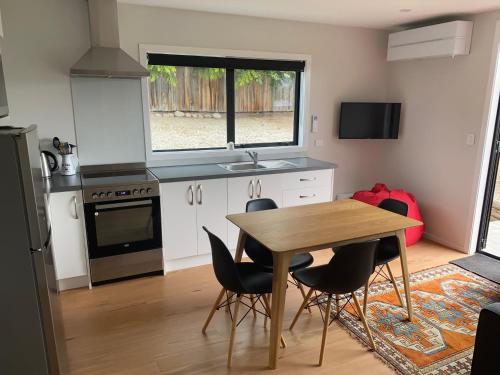 a kitchen with a table and chairs and a window at Tekapo Haven - Lake Tekapo in Lake Tekapo