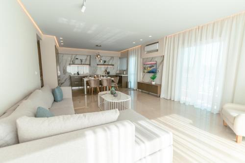 a living room with a white couch and a table at Designer Stay 100sqm, Wood & Marble , 5min to Sea in Platánion