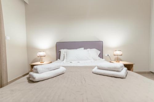 a bedroom with a large white bed with two lamps at Elegant Suite 5' Min Kos Central in Platánion