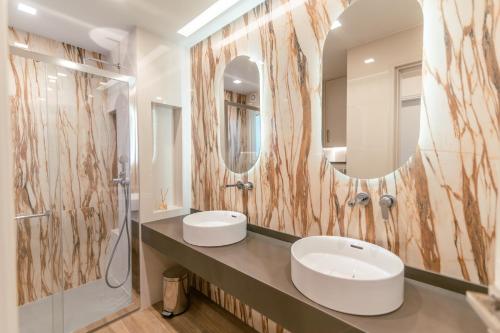 a bathroom with two sinks and a large mirror at Elegant Suite 5' Min Kos Central in Platánion
