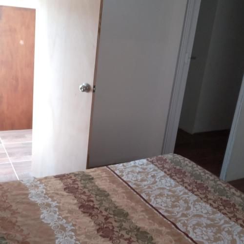 - une chambre avec un lit doté d'une couette brune et blanche dans l'établissement Hostal DOÑA EMMA, à Florida