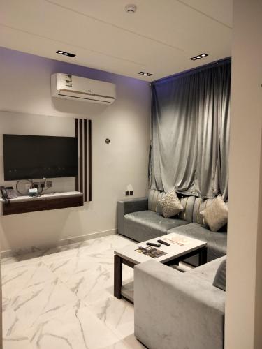 sala de estar con sofá y TV en مساكن الريان, en Riad