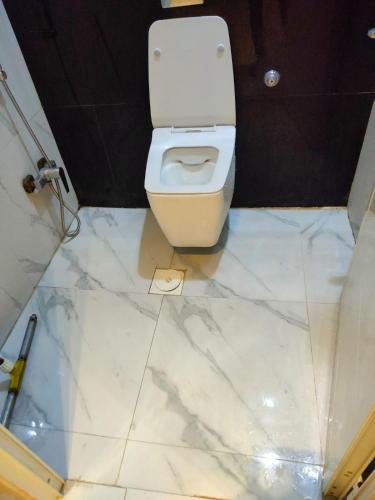 baño con aseo blanco y suelo de baldosa en مساكن الريان, en Riad