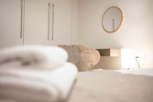 a white bedroom with a bed and a mirror at Designer Stay 100sqm, Wood & Marble , 5min to Sea in Platánion