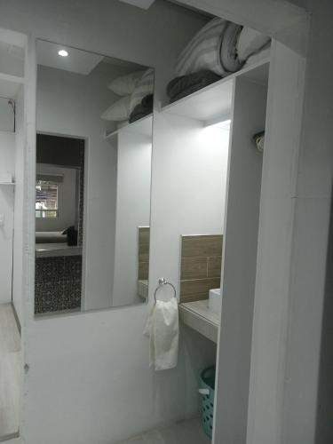 een witte badkamer met een spiegel en een wastafel bij EL LOFT DE COYOACAN in Mexico-Stad
