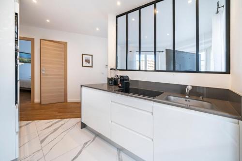 - une cuisine avec un évier et un miroir dans l'établissement Wonderful 2 bedroom apartment, à Cannes