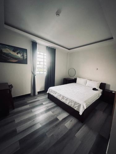 芹苴的住宿－T ONE II HOSTEL，卧室配有白色的床和窗户。