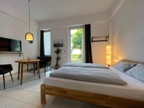 a bedroom with a large bed and a table at The East Apartment by Rabe - Netflix & Coffee & Parkplatz in Karlsruhe
