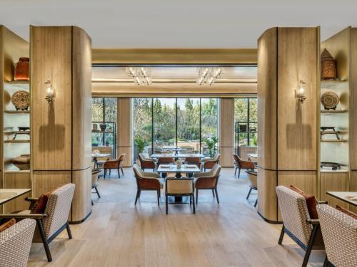 a restaurant with tables and chairs and large windows at InterContinental Chiang Mai The Mae Ping in Chiang Mai
