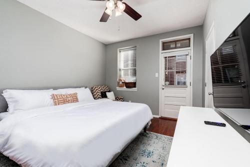 a bedroom with a white bed and a ceiling fan at 3 King Beds/Charm in Historic STL by StayStLouis in Soulard
