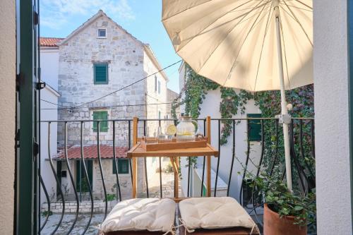 a balcony with a table and an umbrella at Heritage House in Historic Center of Split in Split