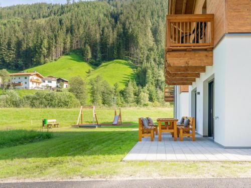 a patio with a table and chairs and a playground at Chalet Joep in Wald im Pinzgau