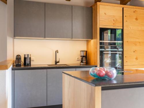 a kitchen with gray cabinets and a bowl of fruit on a counter at Chalet Joep in Wald im Pinzgau