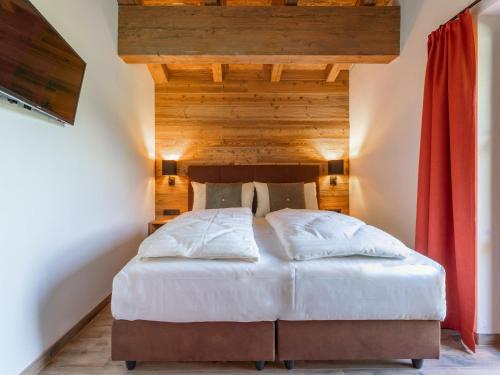 a bedroom with a bed with a wooden ceiling at Chalet Joep in Wald im Pinzgau