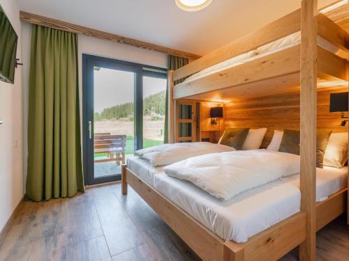 a bedroom with a large bed and a large window at Chalet Joep in Wald im Pinzgau