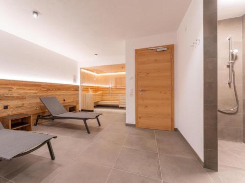 a bathroom with a shower and a bench and a chair at Chalet Joep in Wald im Pinzgau