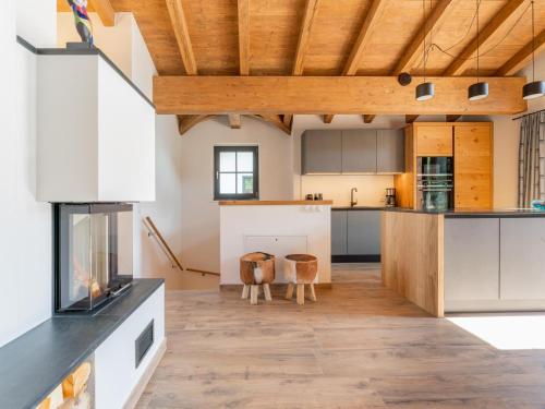 a kitchen with white cabinets and a wooden ceiling at Chalet Joep in Wald im Pinzgau