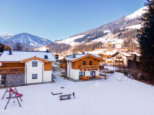 a group of buildings in the snow with mountains at Chalet Joep in Wald im Pinzgau