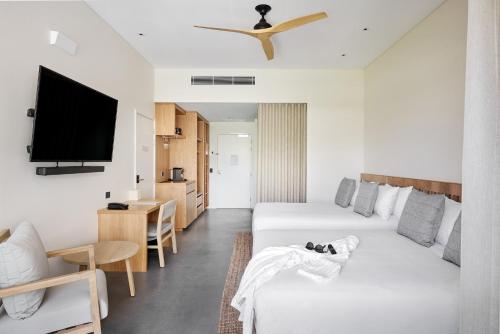 a living room with a white couch and a tv at Samphire Rottnest in Rottnest Island
