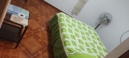 Cama verde en habitación con mesa en Punto surf terrace, en Pacasmayo