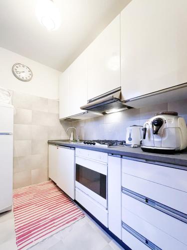 a kitchen with white cabinets and a stove top oven at Balcone sulla Valmalenco - Vista mozzafiato in Chiesa in Valmalenco