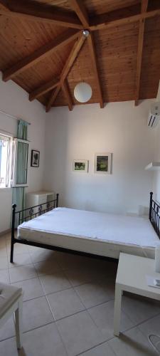 Cette chambre comprend un grand lit et un plafond en bois. dans l'établissement Villa Pilias, à Methoni